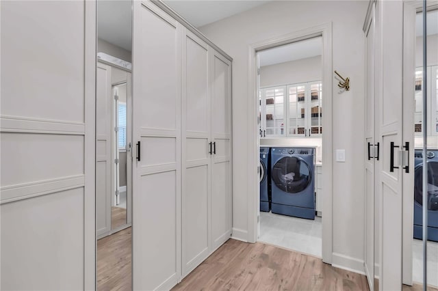 clothes washing area featuring light hardwood / wood-style floors and separate washer and dryer