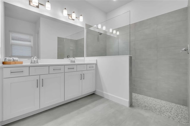 bathroom with tiled shower and vanity