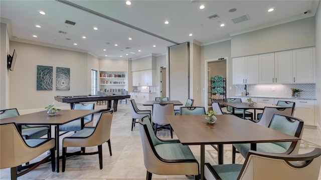 tiled dining area featuring crown molding