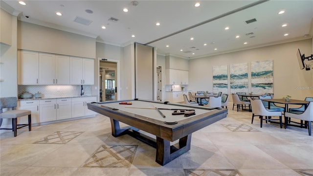 rec room featuring a towering ceiling, billiards, ornamental molding, and light tile patterned flooring