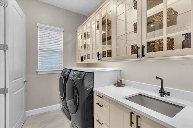 laundry room featuring cabinets, sink, washing machine and dryer, and light tile patterned flooring