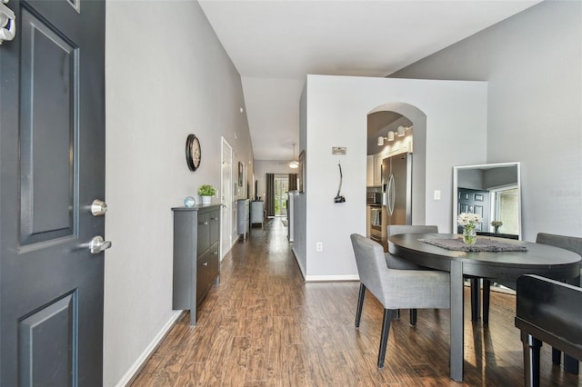 dining room with a high ceiling and dark hardwood / wood-style floors