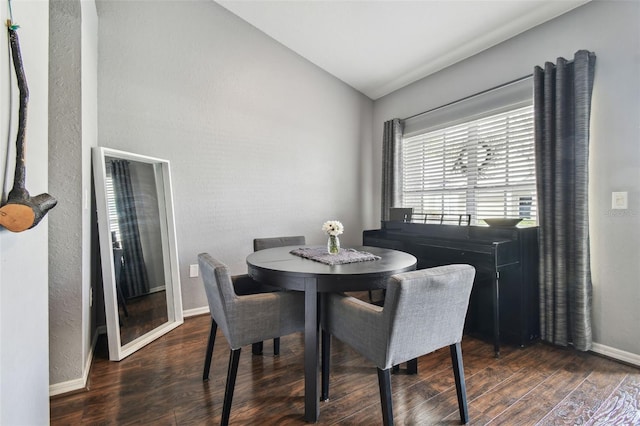 dining area featuring lofted ceiling and dark hardwood / wood-style flooring