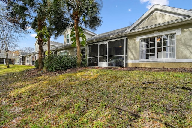 rear view of property featuring a sunroom and a yard