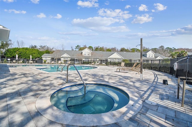 view of swimming pool featuring a hot tub and a patio area