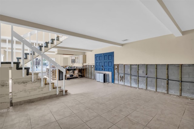 interior space with light tile patterned flooring and beam ceiling