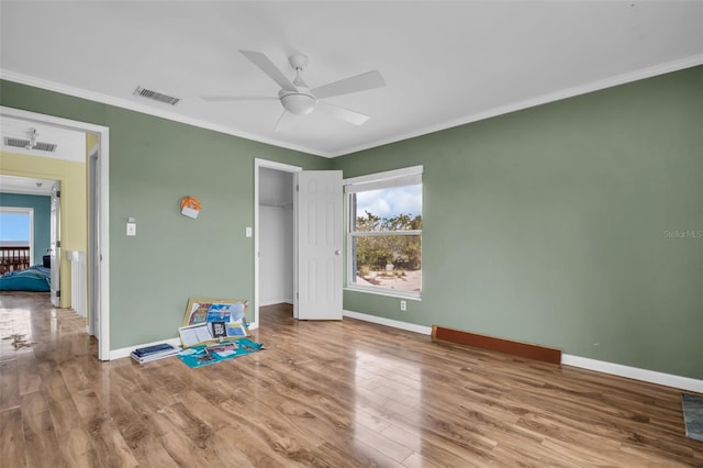 unfurnished bedroom with ceiling fan, ornamental molding, and hardwood / wood-style flooring