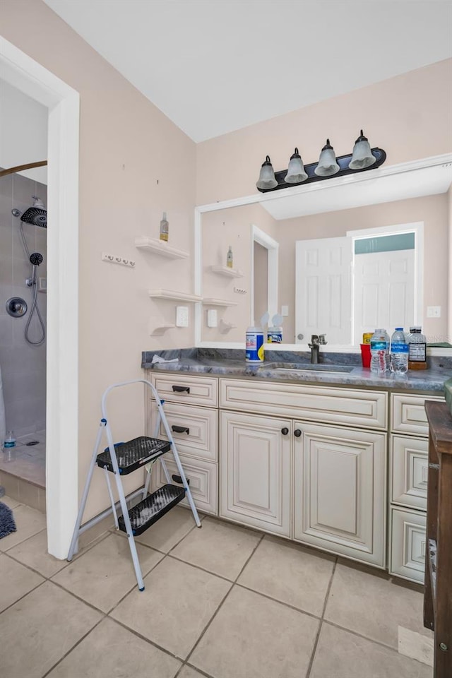 bathroom featuring vanity, tile patterned flooring, and a shower