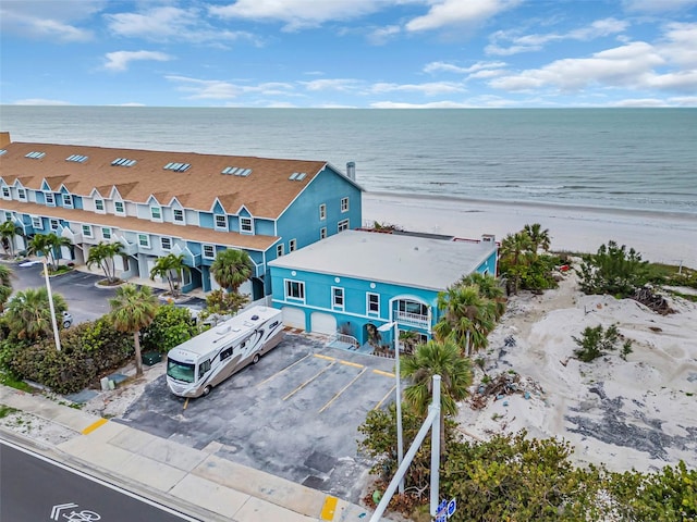 drone / aerial view featuring a water view and a view of the beach