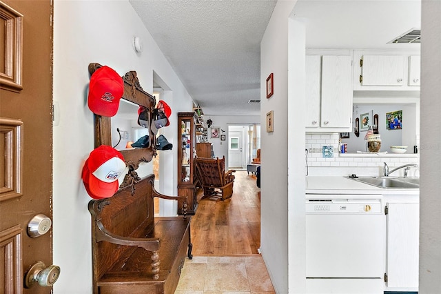 hall featuring sink and a textured ceiling