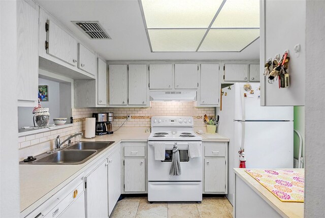 kitchen with backsplash, white appliances, sink, and light tile patterned flooring