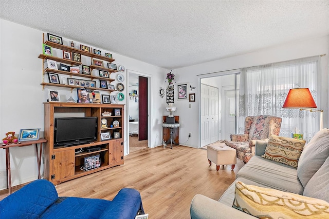 living room featuring a textured ceiling and light hardwood / wood-style flooring