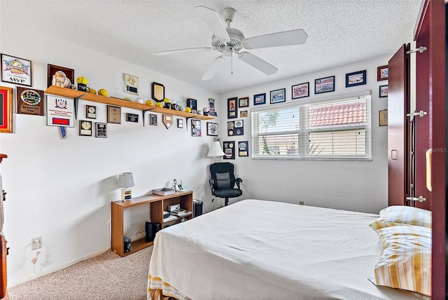 bedroom with ceiling fan, light colored carpet, and a textured ceiling