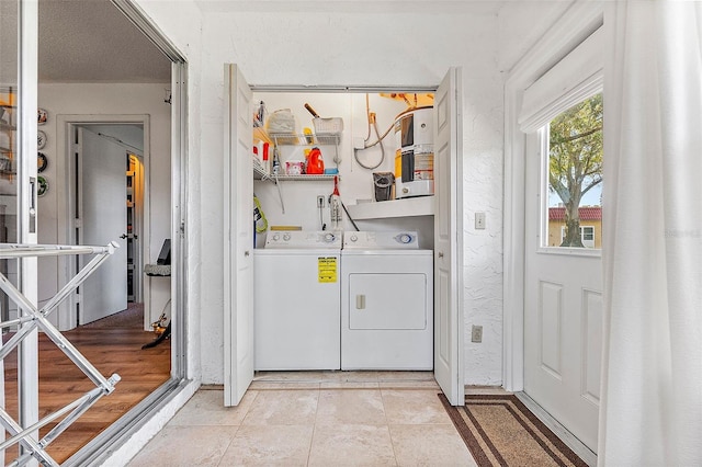 laundry area with light tile patterned floors, independent washer and dryer, and a textured ceiling