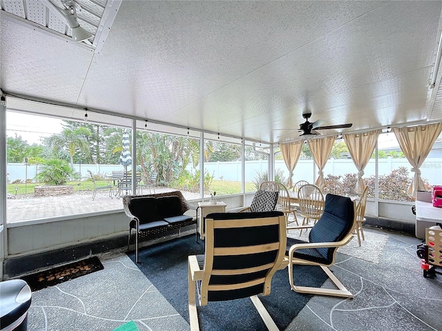 sunroom / solarium with ceiling fan, plenty of natural light, and a water view