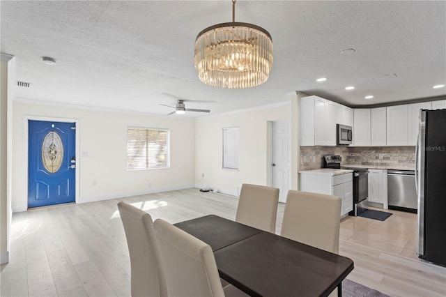 dining room with crown molding, a textured ceiling, and light hardwood / wood-style flooring