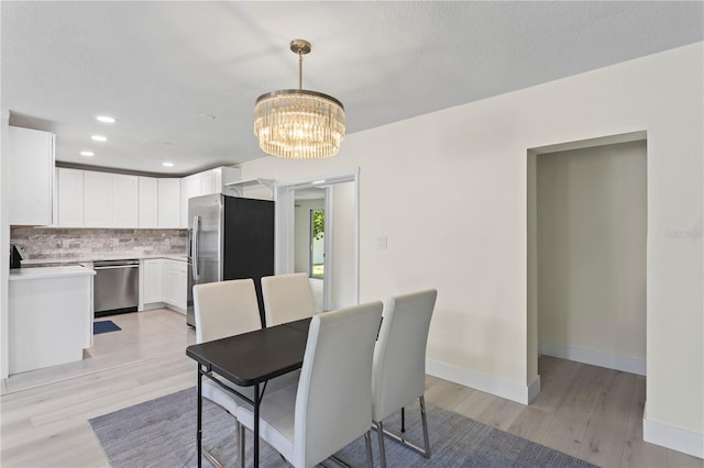 dining space with a chandelier and light wood-type flooring