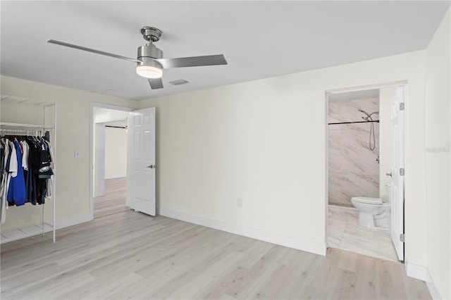 unfurnished bedroom featuring connected bathroom, light hardwood / wood-style floors, a closet, and ceiling fan