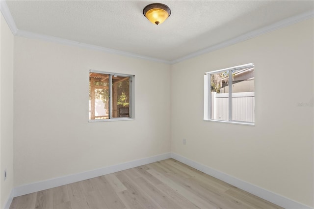 unfurnished room featuring crown molding, light hardwood / wood-style flooring, and a textured ceiling