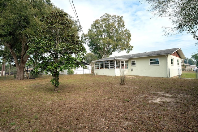 back of property with a yard and a sunroom