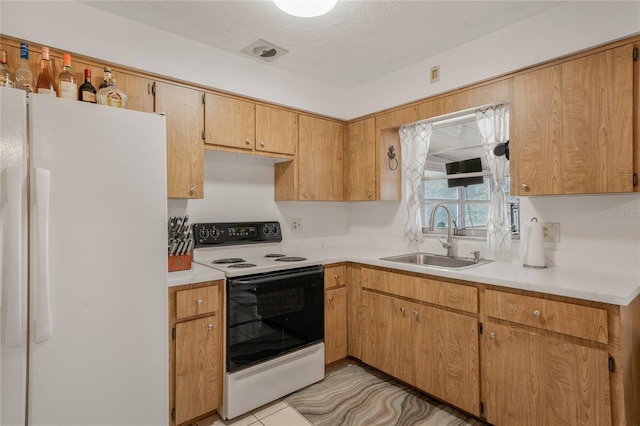 kitchen with light tile patterned flooring, sink, a textured ceiling, and white appliances