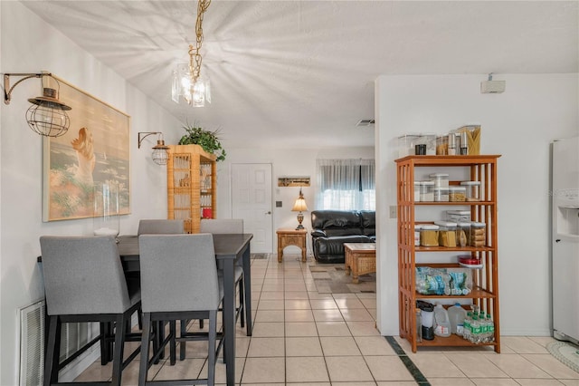 dining space with light tile patterned floors and a notable chandelier