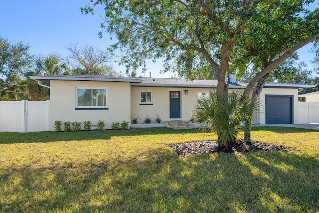 single story home featuring a garage and a front lawn