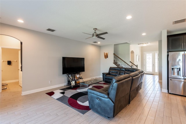 living room with ceiling fan, french doors, and a textured ceiling