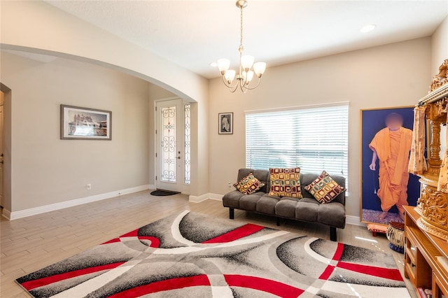 living room with light hardwood / wood-style floors and a notable chandelier