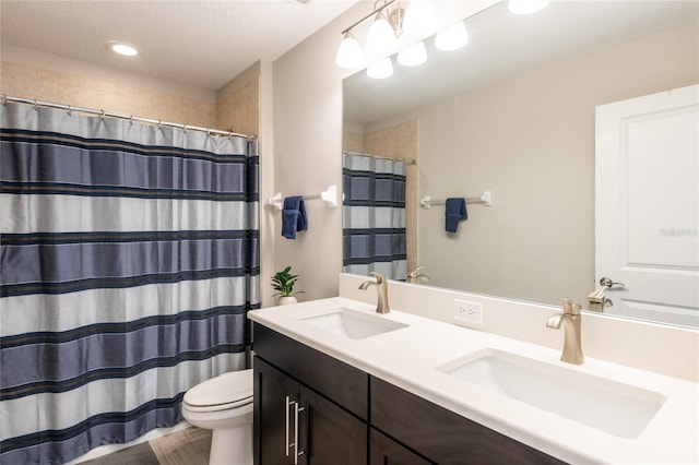 bathroom with walk in shower, vanity, a textured ceiling, and toilet