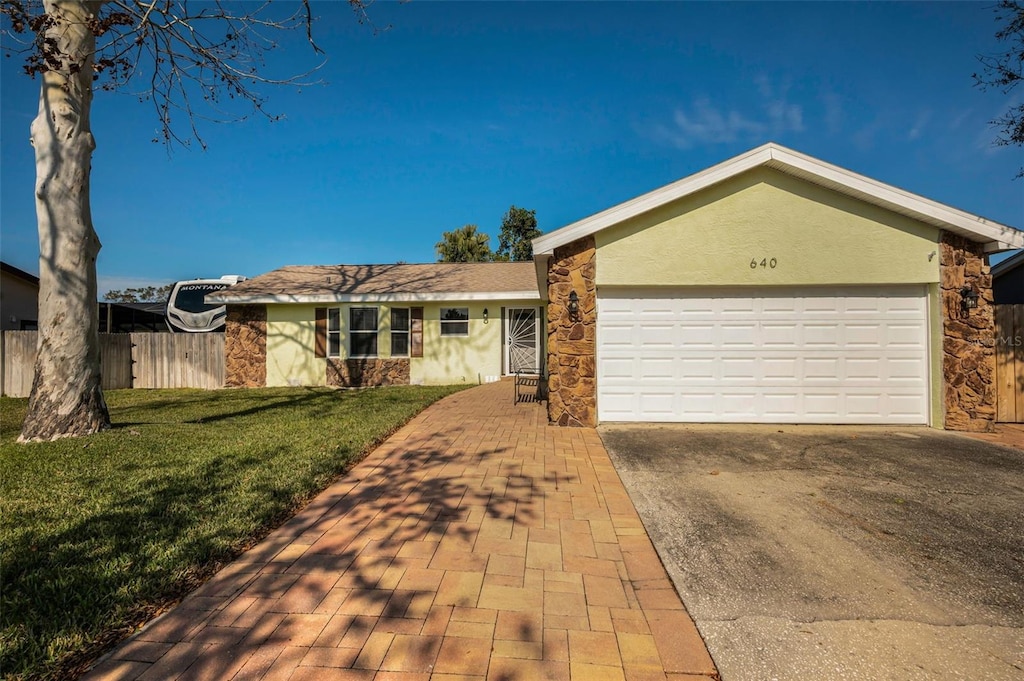 ranch-style house with a garage and a front lawn