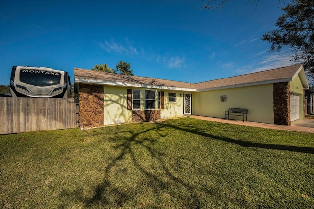 back of property with a garage and a yard