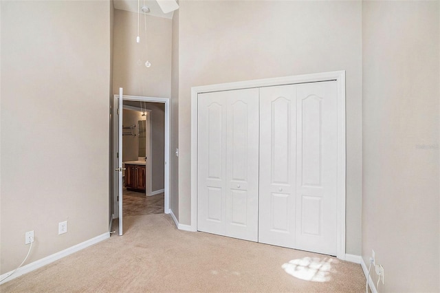 unfurnished bedroom featuring a closet and light carpet