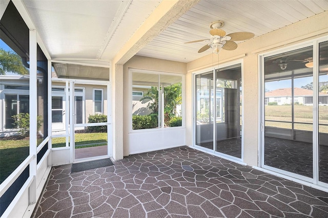 unfurnished sunroom with ceiling fan