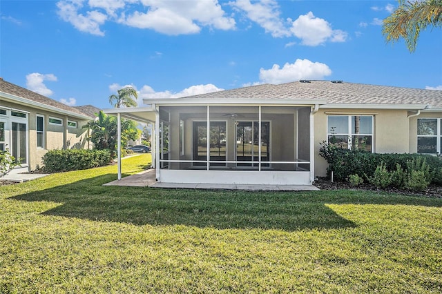 rear view of property featuring a yard and a sunroom