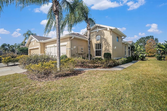 view of side of property with a garage and a lawn