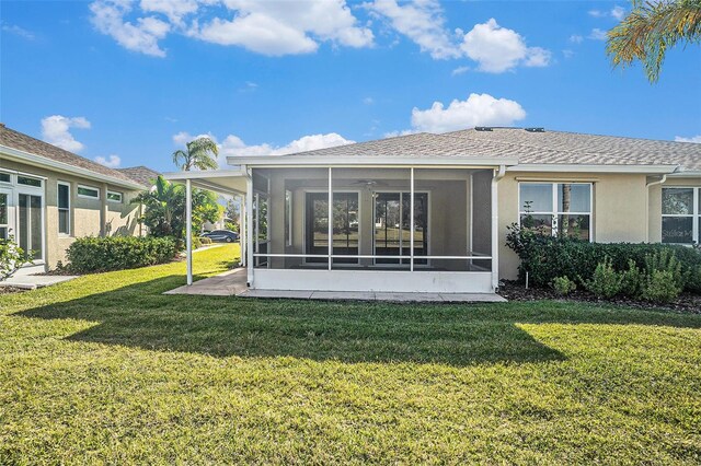 back of property with a yard and a sunroom