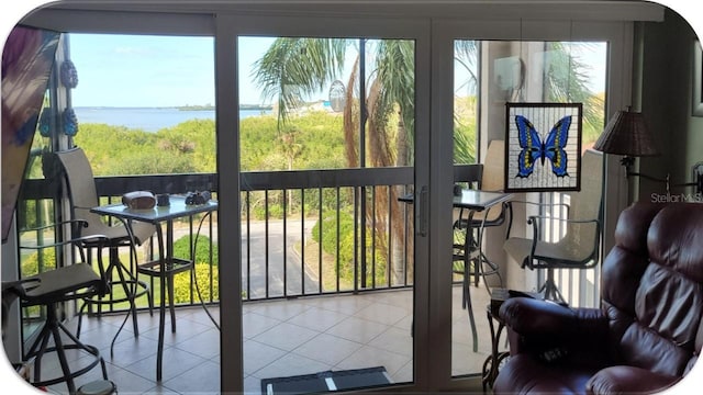 entryway with a water view, tile patterned floors, and plenty of natural light