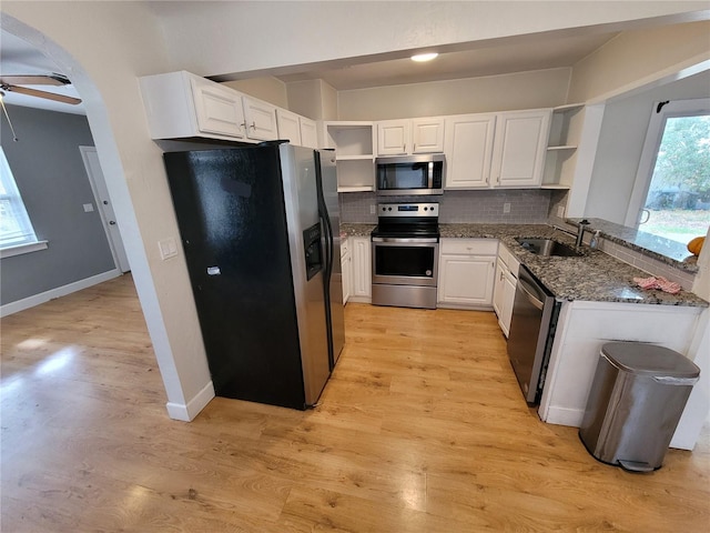 kitchen with sink, white cabinets, tasteful backsplash, dark stone counters, and appliances with stainless steel finishes