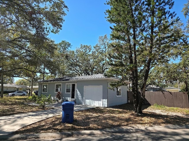 single story home with a garage, fence, and concrete driveway