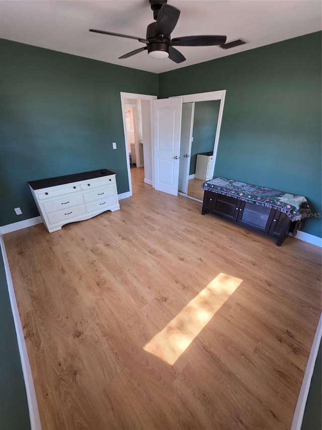 unfurnished bedroom with light wood-type flooring, baseboards, visible vents, and ceiling fan