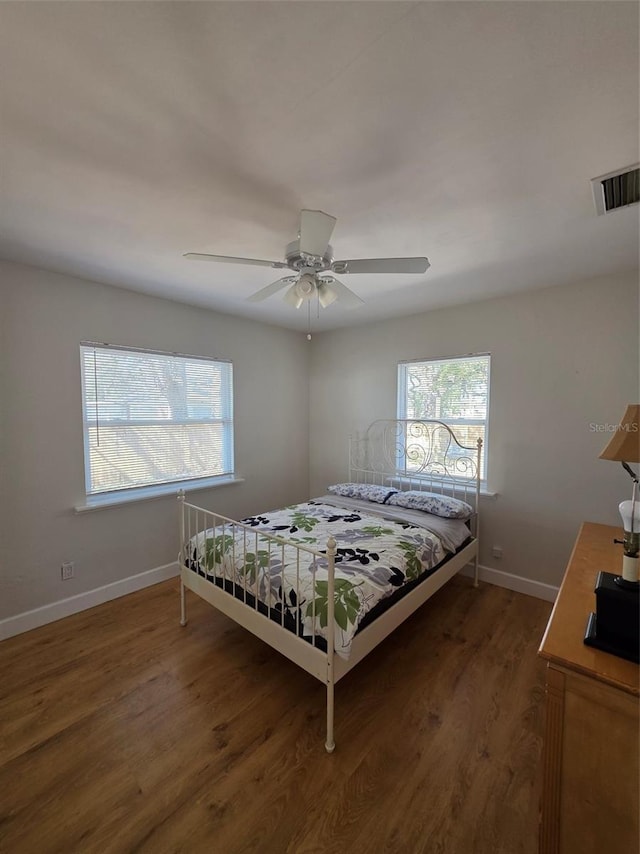 bedroom with multiple windows, wood finished floors, and visible vents