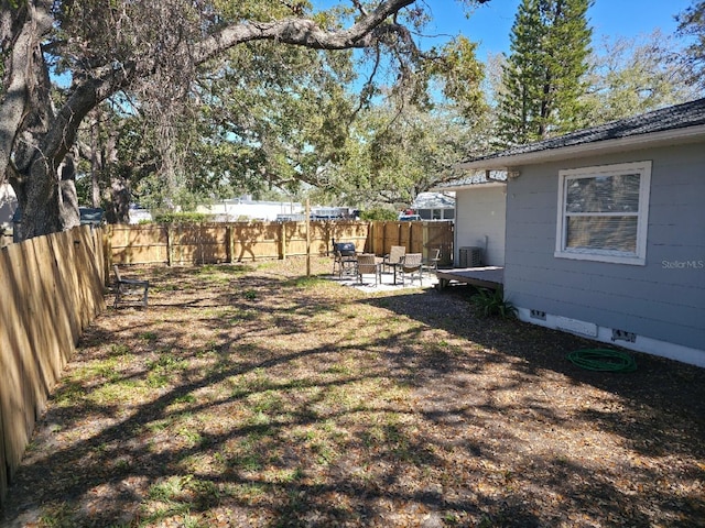 view of yard featuring a patio area, a fenced backyard, and central AC