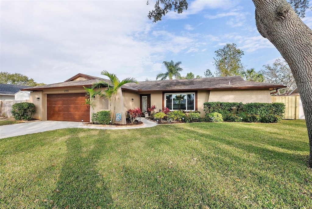 single story home with a front yard and a garage