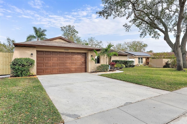 ranch-style home featuring solar panels, a front lawn, and a garage