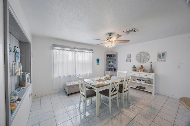 tiled dining space featuring ceiling fan and a textured ceiling