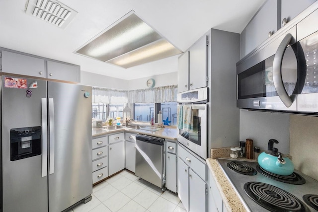 kitchen with light tile patterned flooring, white cabinetry, and appliances with stainless steel finishes