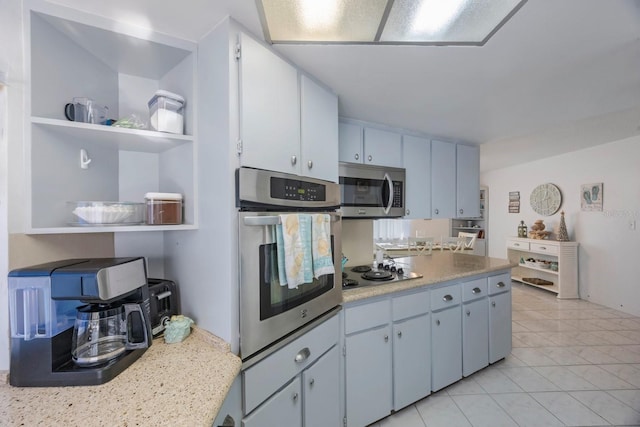 kitchen featuring light tile patterned flooring, white cabinetry, and stainless steel appliances