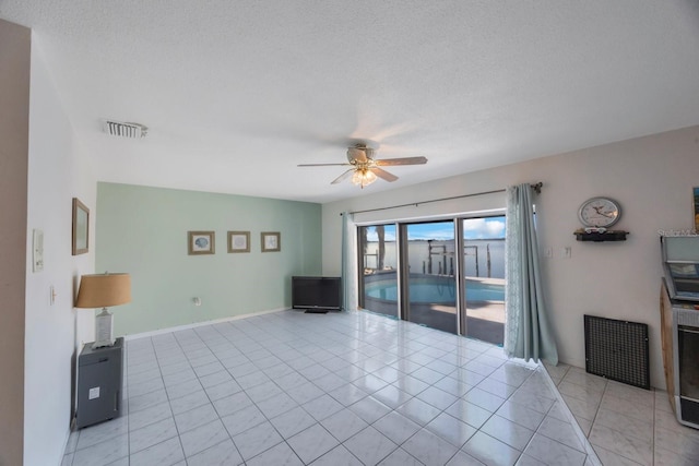 tiled living room with ceiling fan and a textured ceiling