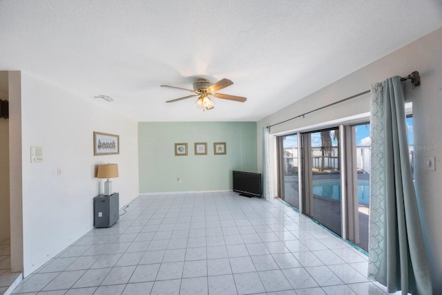 tiled empty room featuring a textured ceiling and ceiling fan